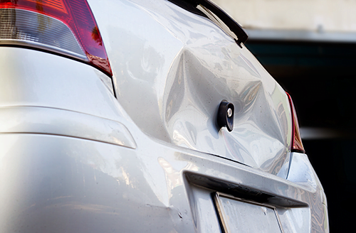 large dent on trunk of car